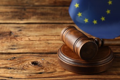 Photo of Judge's gavel and European Union flag on wooden table. Space for text