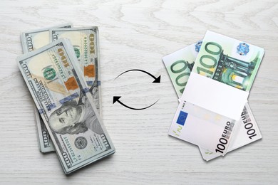 Image of Currency exchange. Circle arrows between dollars and euro banknotes on white wooden background, flat lay