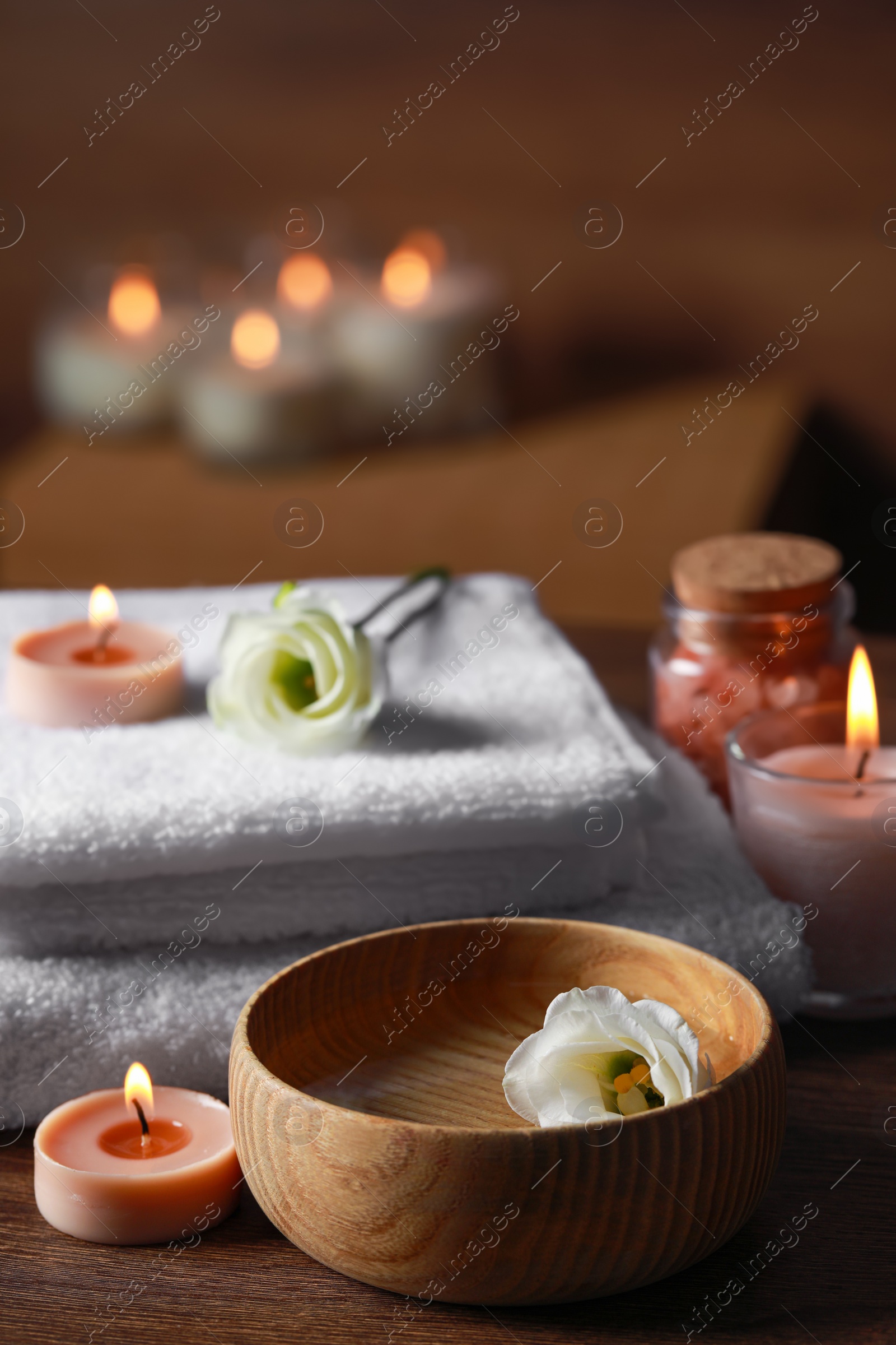 Photo of Beautiful spa composition with burning candles and flowers on wooden table