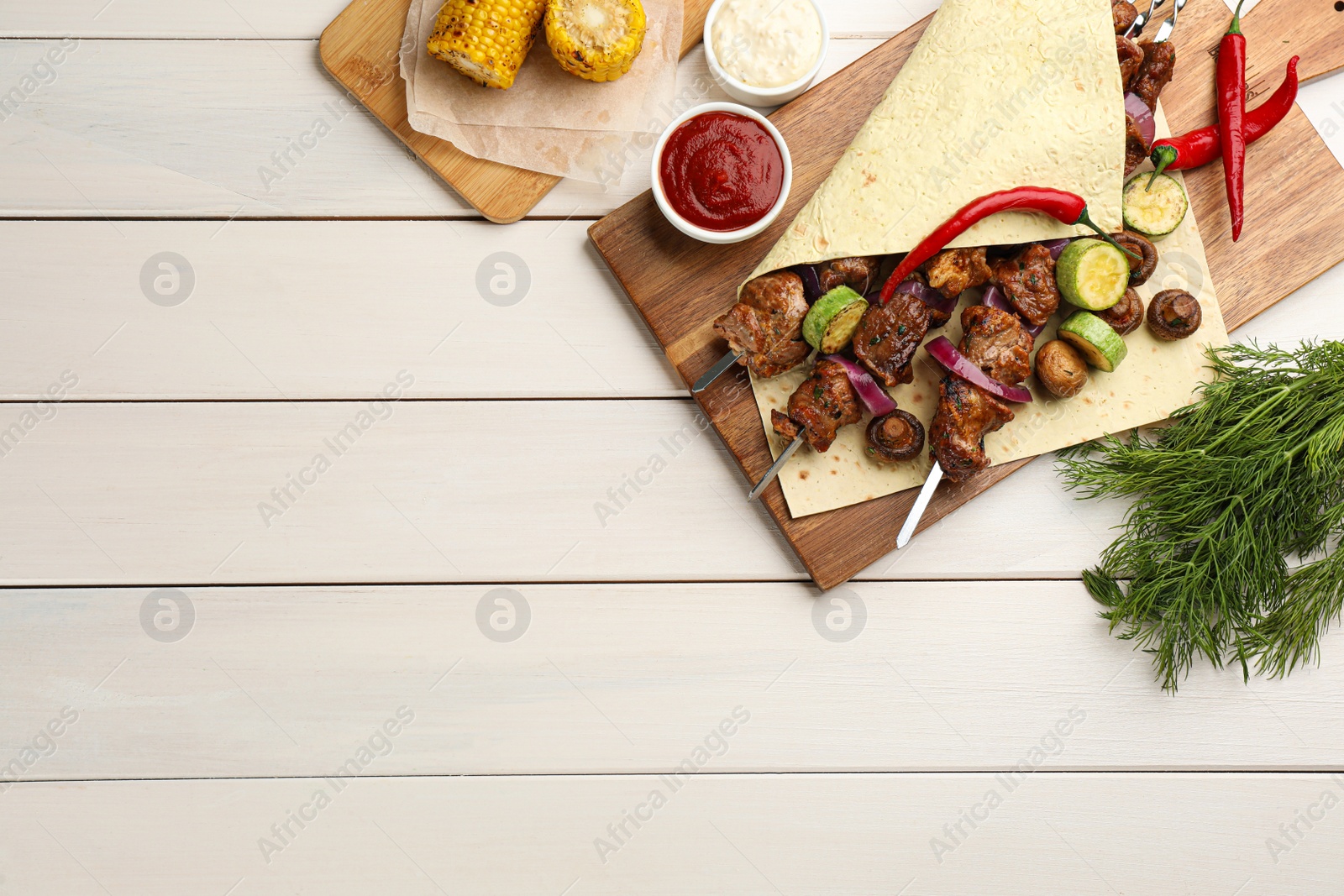Photo of Metal skewers with delicious meat and vegetables served on white wooden table, flat lay. Space for text