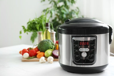 Modern multi cooker and products on kitchen table