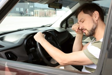 Photo of Sleepy tired man in his modern car