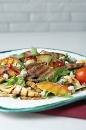 Delicious salad with beef tongue, grilled vegetables, peach and blue cheese on white table, closeup