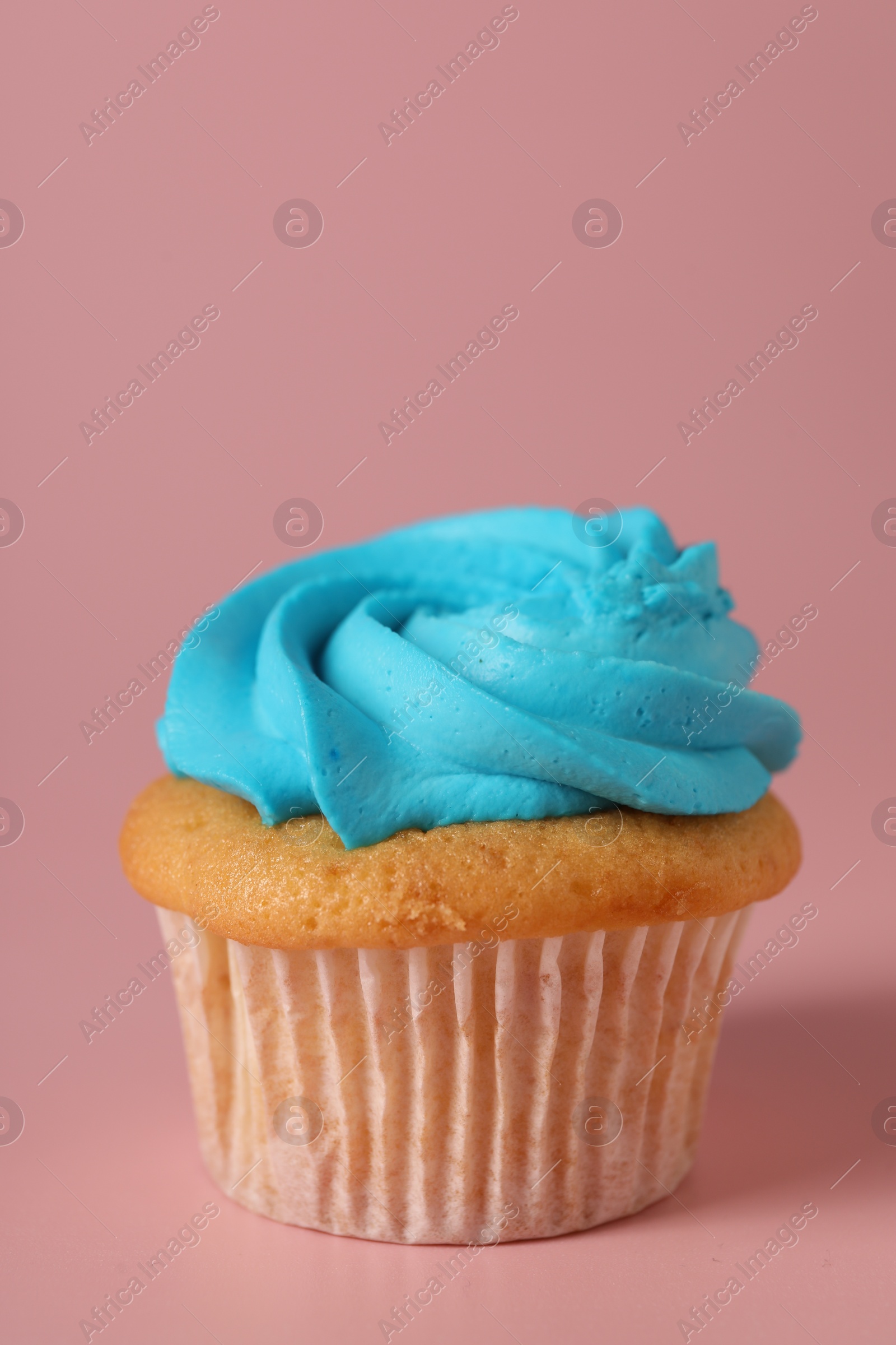 Photo of Delicious cupcake with bright cream on pink background, space for text