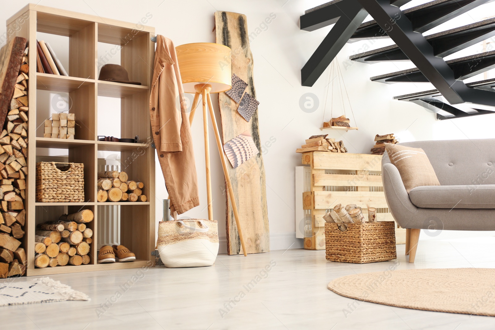 Photo of Stylish room interior with firewood as decorative element