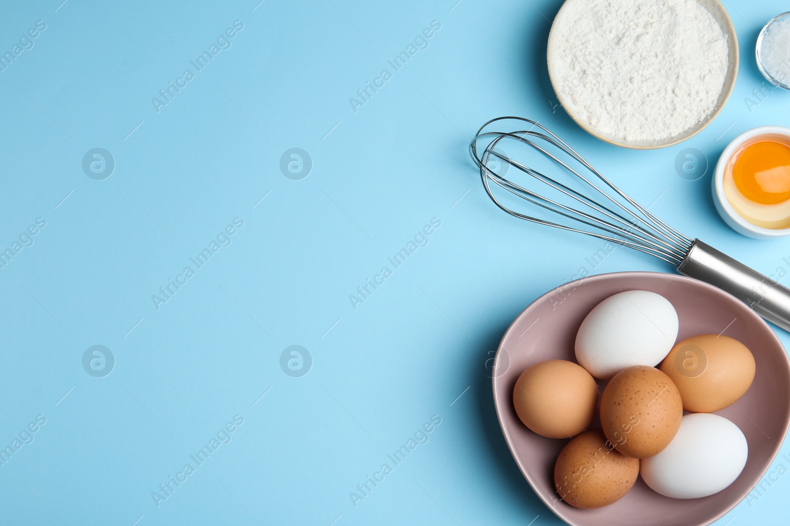 Photo of Flat lay composition with chicken eggs on light blue background. Space for text