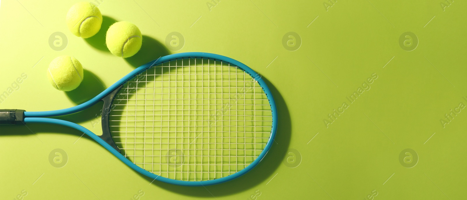 Image of Tennis racket and balls on green background, flat lay. Banner design with space for text