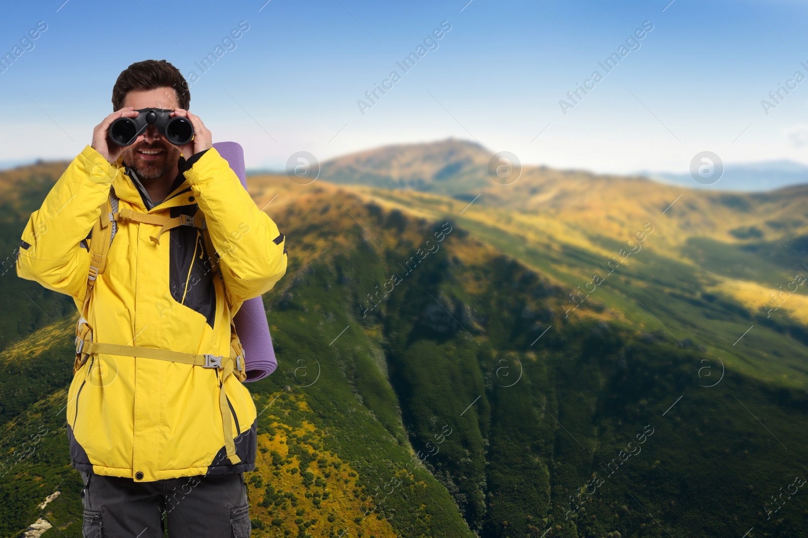 Image of Tourist with backpack and binoculars in mountains