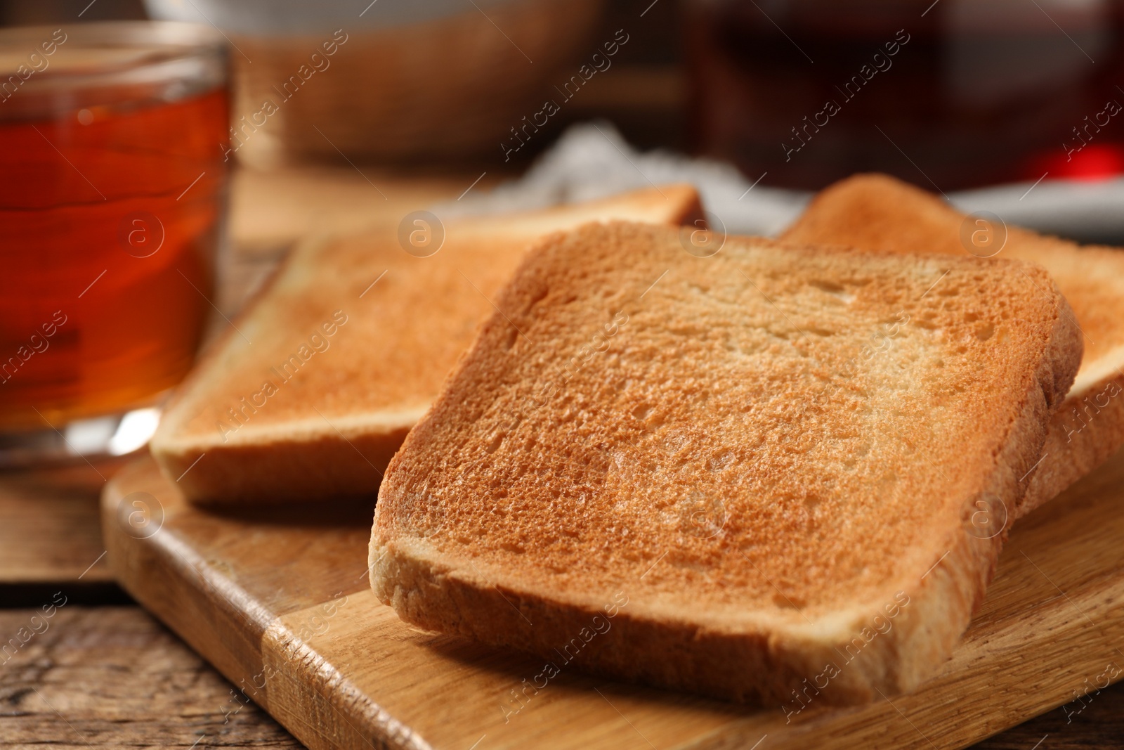 Photo of Slices of tasty toasted bread on wooden table, closeup