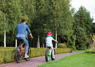 Dad and son riding modern bicycles outdoors