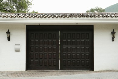 Photo of White wall with beautiful black gates. Exterior design