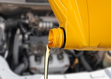 Image of Pouring motor oil from yellow container, closeup