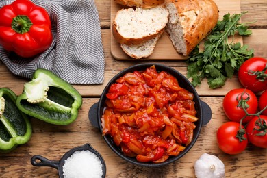 Photo of Delicious lecho and ingredients on wooden table, flat lay