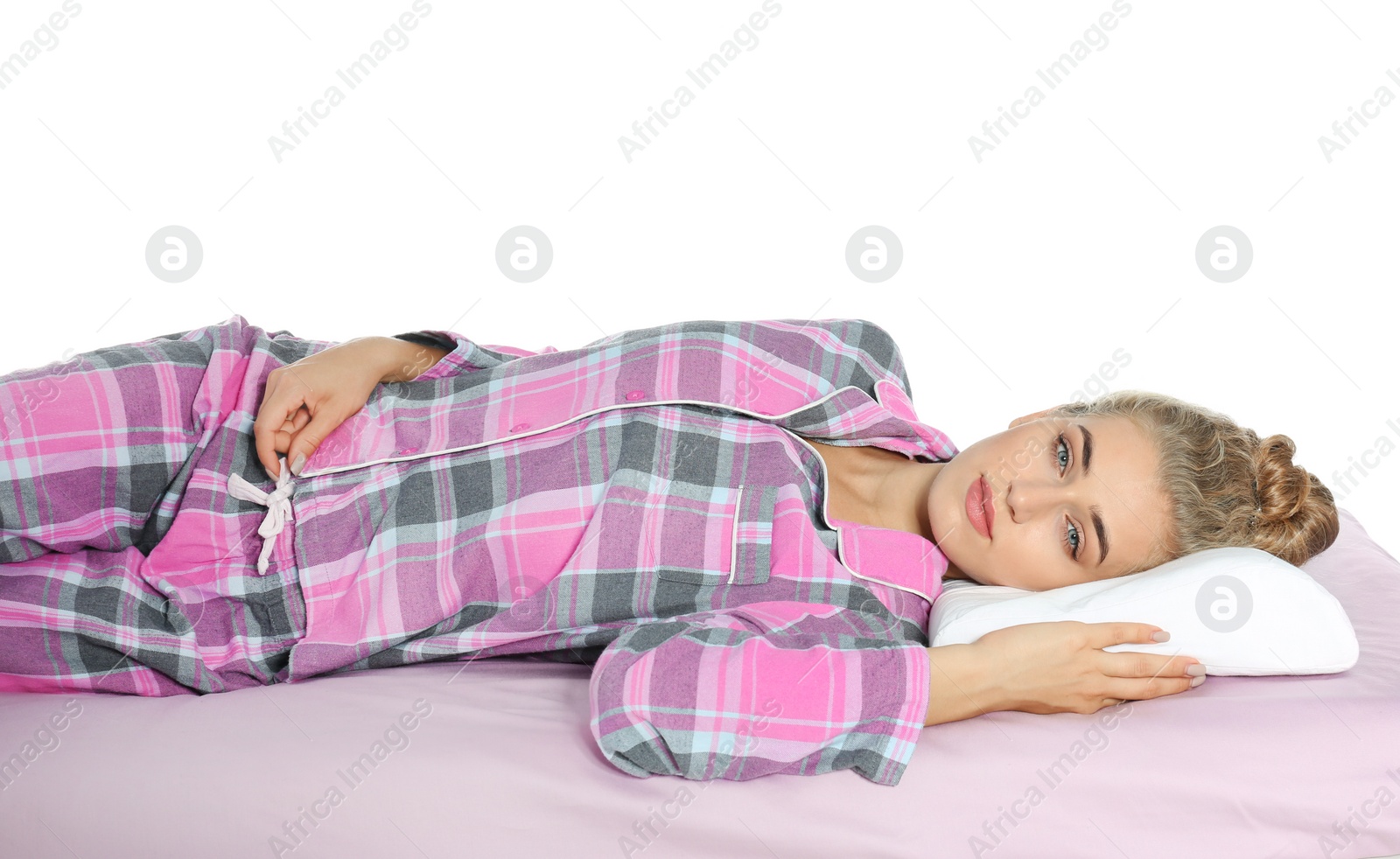 Photo of Beautiful woman lying with orthopedic pillow on bed against white background