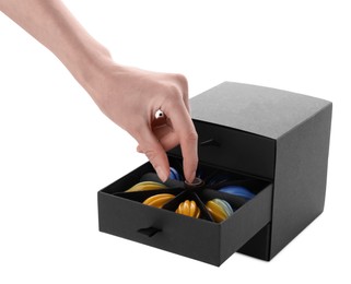 Photo of Woman taking delicious chocolate candy from black box on white background, closeup