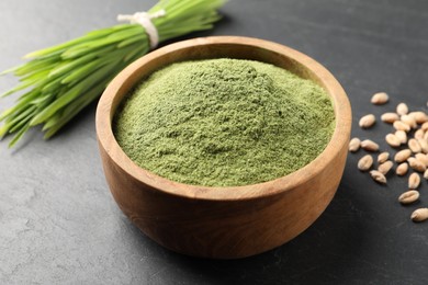 Wheat grass powder in bowl on grey table, closeup