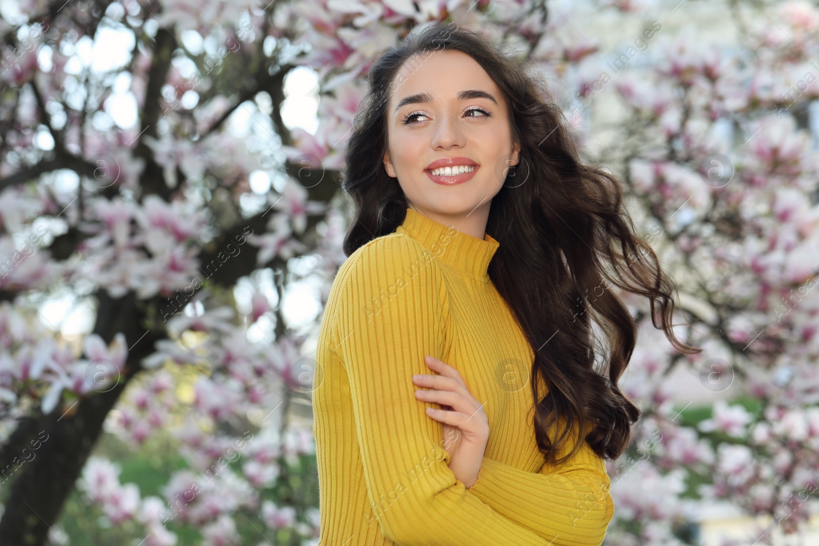 Photo of Beautiful woman near blossoming magnolia tree on spring day