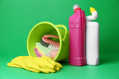 Photo of Bucket, cleaning supplies and tools on green background