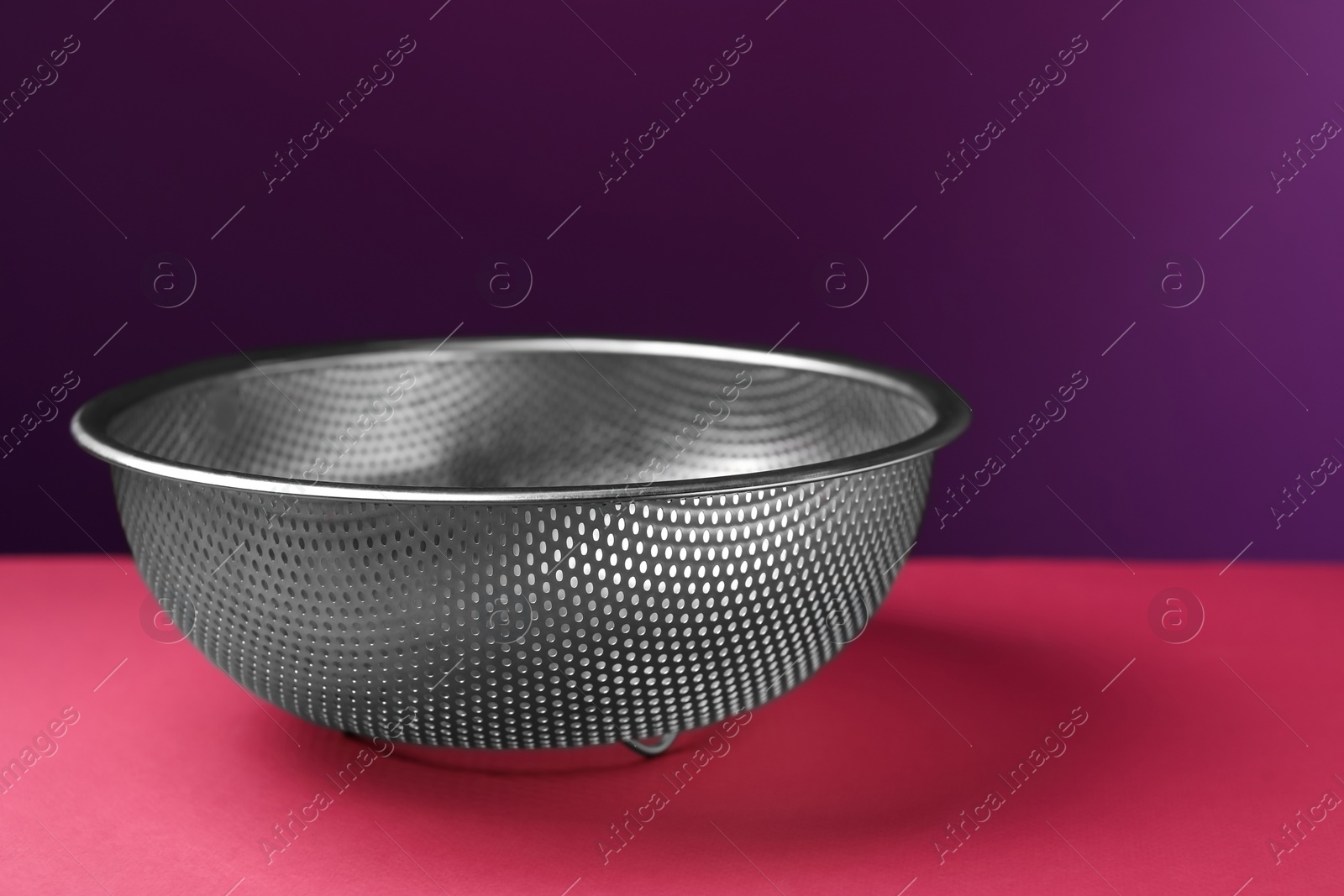 Photo of One clean empty colander on color background, closeup