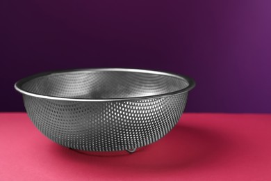 Photo of One clean empty colander on color background, closeup