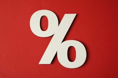 Photo of White percent sign on red background, top view