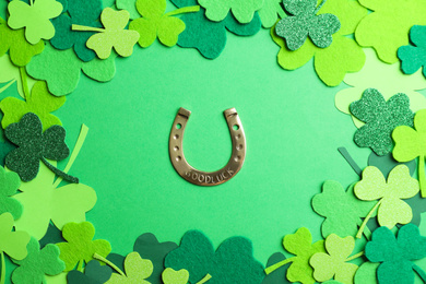 Photo of Flat lay composition with clover leaves and horseshoe on green background. St. Patrick's day