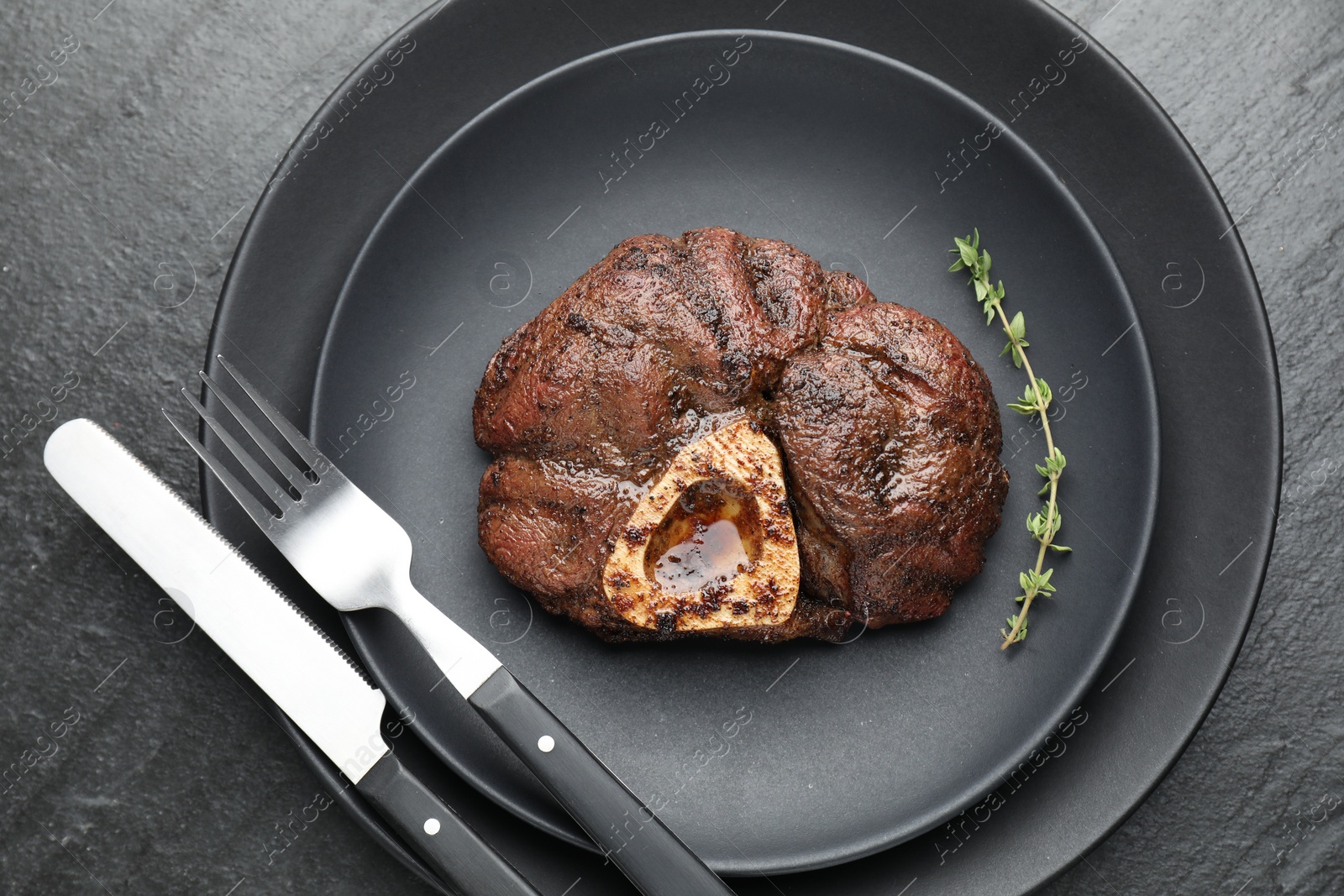 Photo of Tasty grilled beef meat served on black table, top view