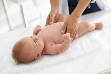 Doctor examining cute baby indoors, closeup. Health care