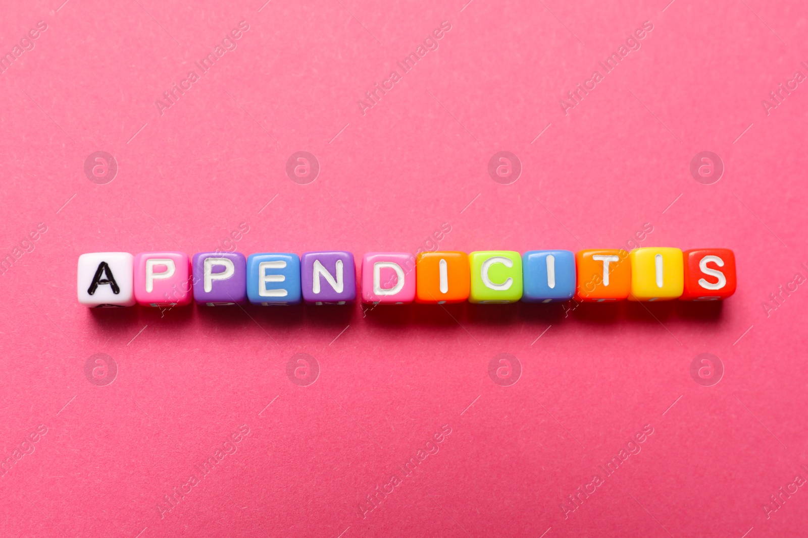 Photo of Word Appendicitis made of color cubes with letters on pink background, top view