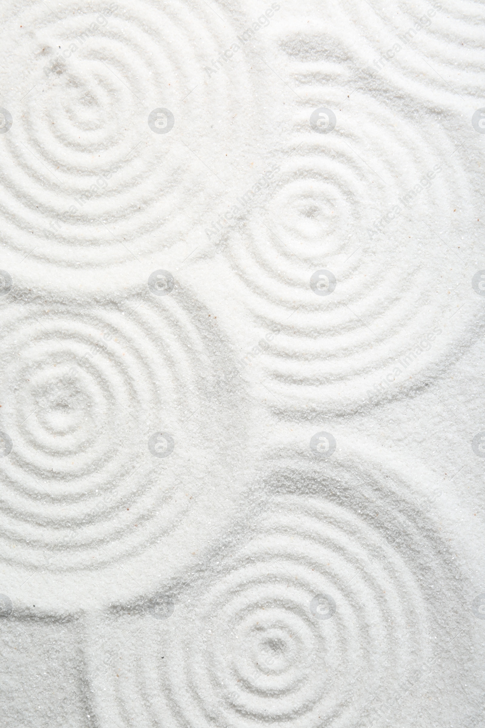 Photo of Zen rock garden. Circle patterns on white sand, top view