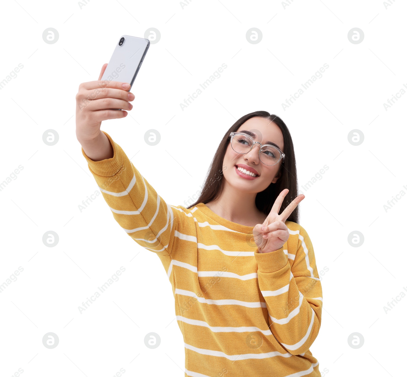 Photo of Smiling young woman taking selfie with smartphone and showing peace sign on white background