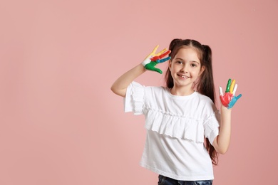 Photo of Little child with painted hands and space for text on color background