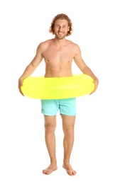 Attractive young man in swimwear with yellow inflatable ring on white background