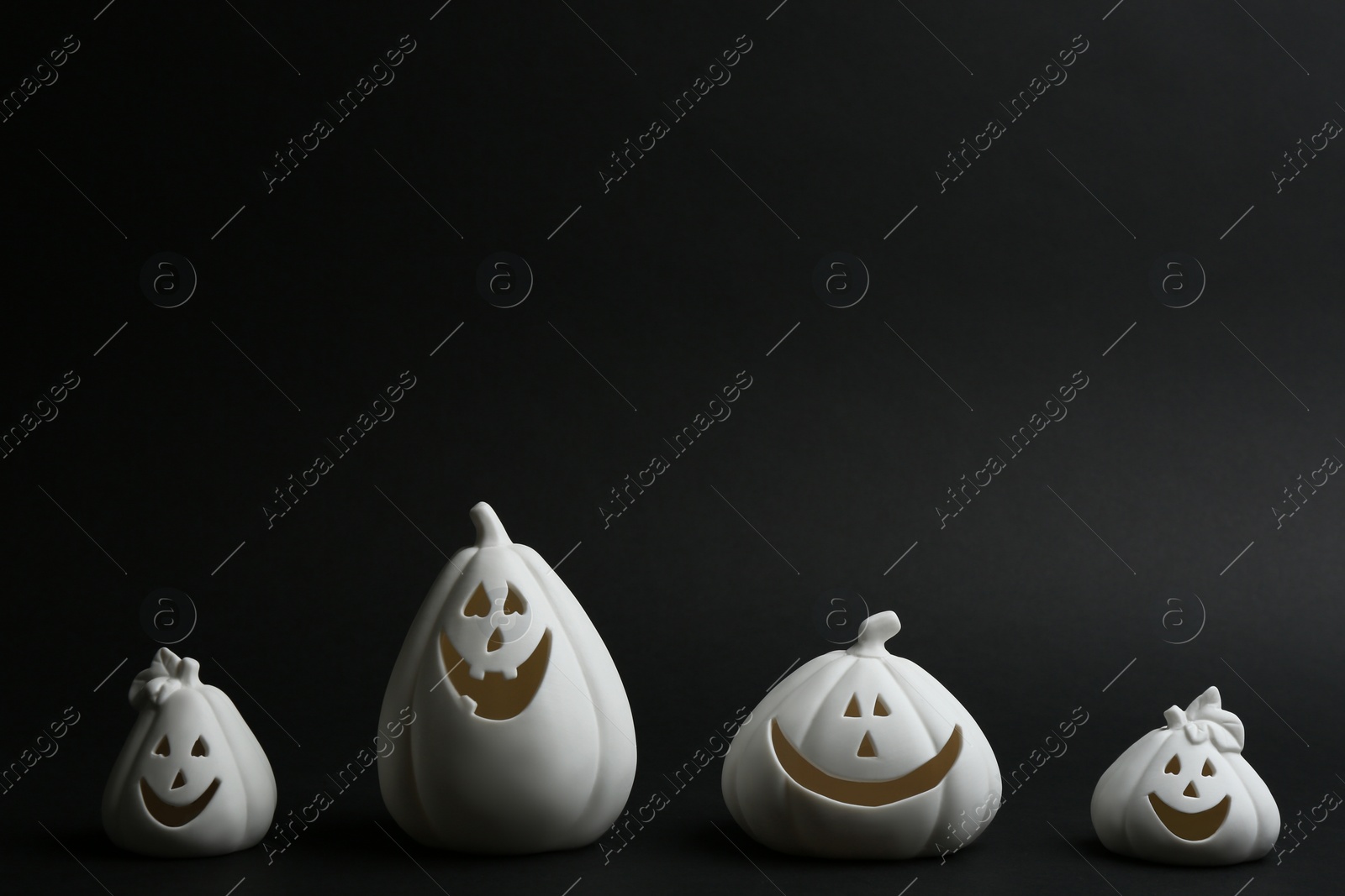 Photo of Jack-o-Lantern candle holders on black background. Halloween decor