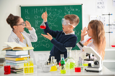Photo of Smart pupils making experiment in chemistry class