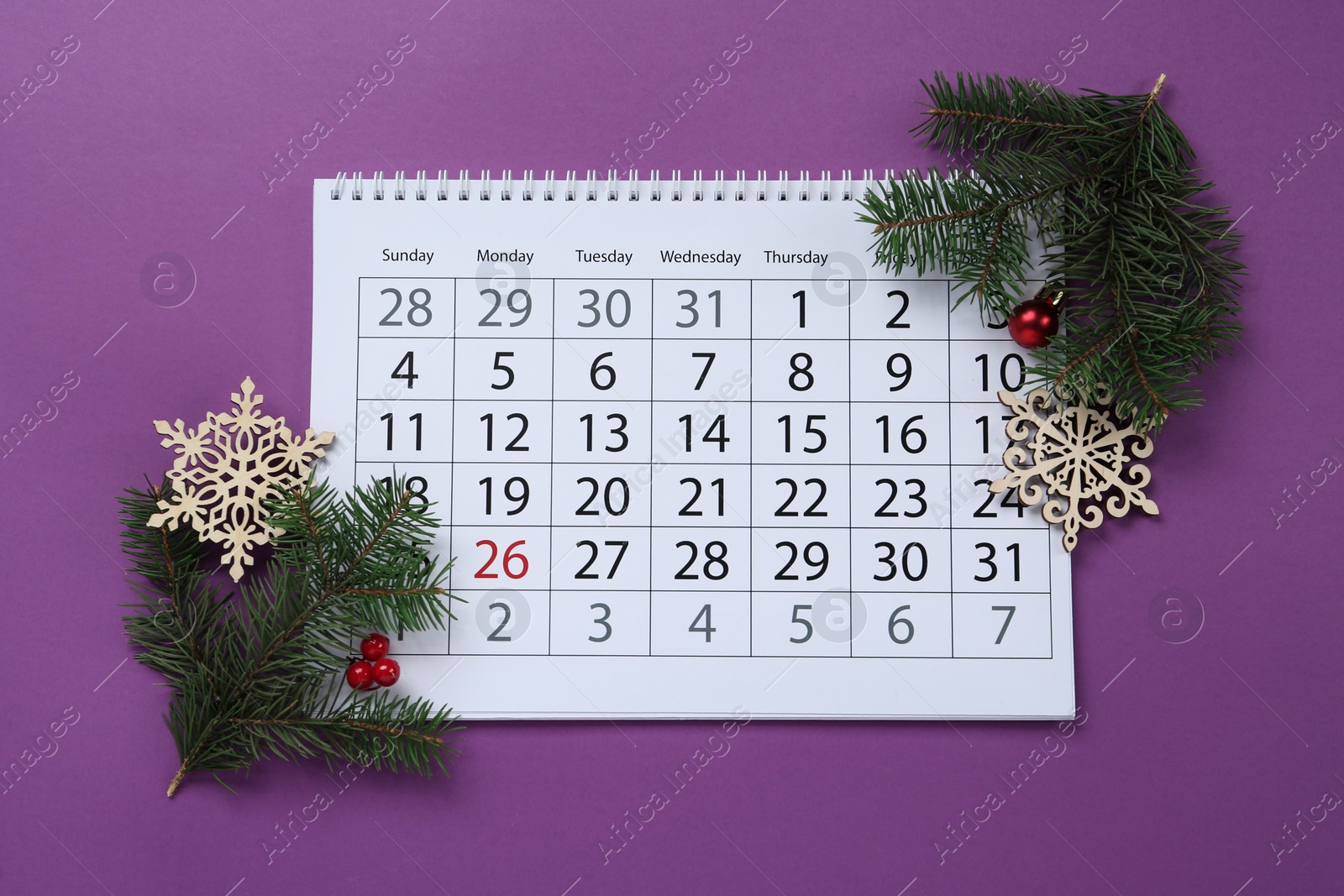 Photo of Composition with calendar, fir branches and Christmas decorations on purple background, flat lay. Boxing day concept