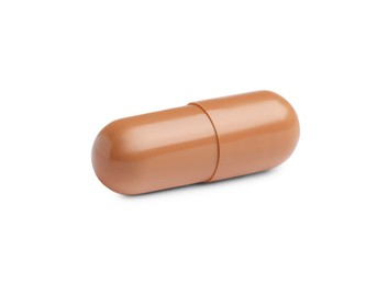 Photo of One brown pill on white background. Medicinal treatment