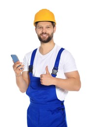 Photo of Professional repairman in uniform with smartphone showing thumbs up on white background