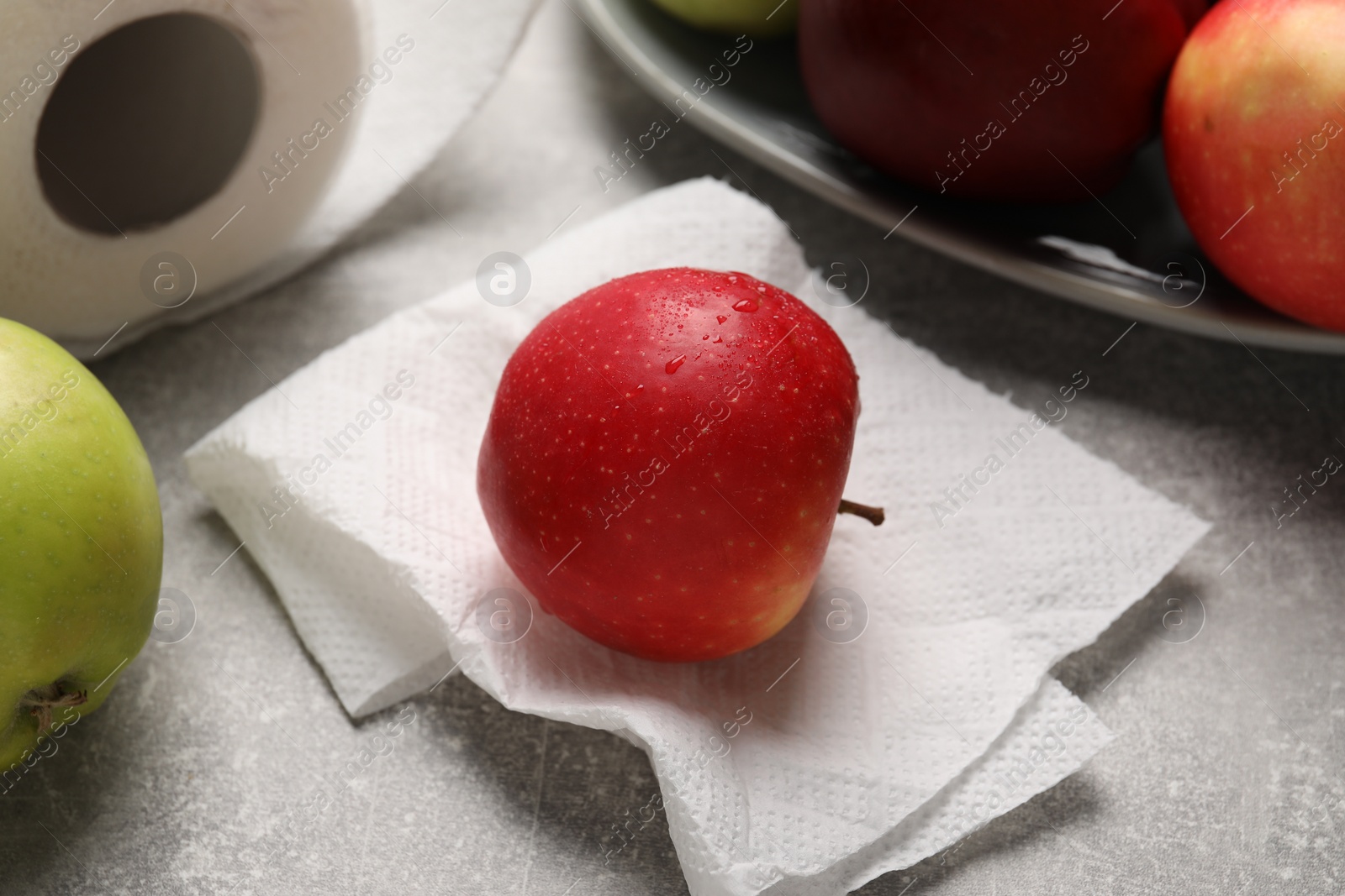 Photo of Paper towel with wet apple on grey textured table