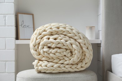 Photo of Soft chunky knit blanket on ottoman indoors
