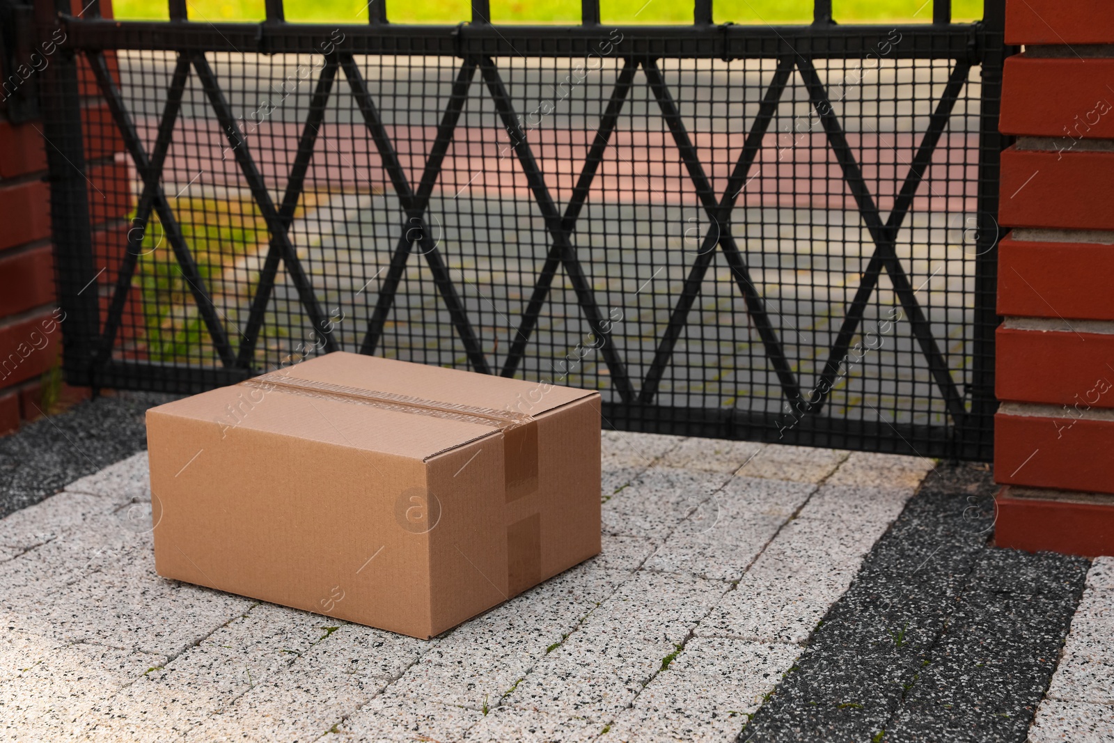 Photo of Cardboard boxes near front gates outdoors. Parcel delivery service