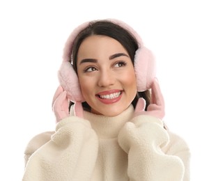 Beautiful young woman wearing earmuffs on white background