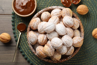 Photo of Bowl of delicious nut shaped cookies on wooden table, flat lay