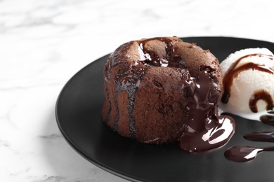 Photo of Plate of delicious fresh fondant with hot chocolate and ice cream on table. Lava cake recipe