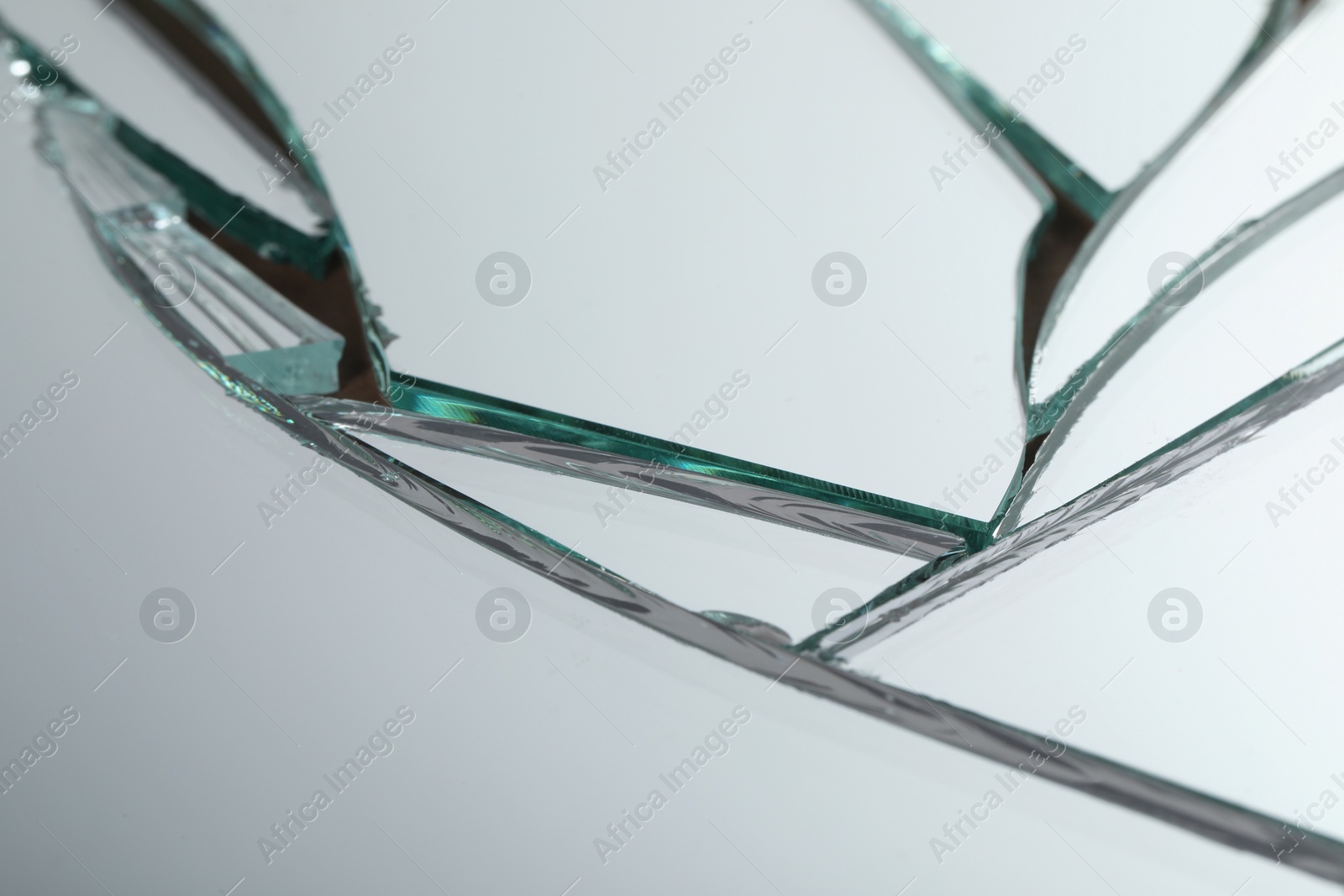 Photo of Broken mirror with many cracks as background, closeup view