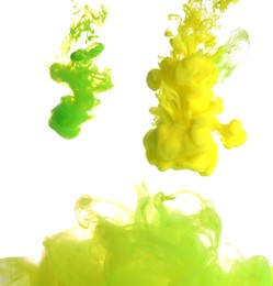 Splashes of yellow and green inks on light background, closeup