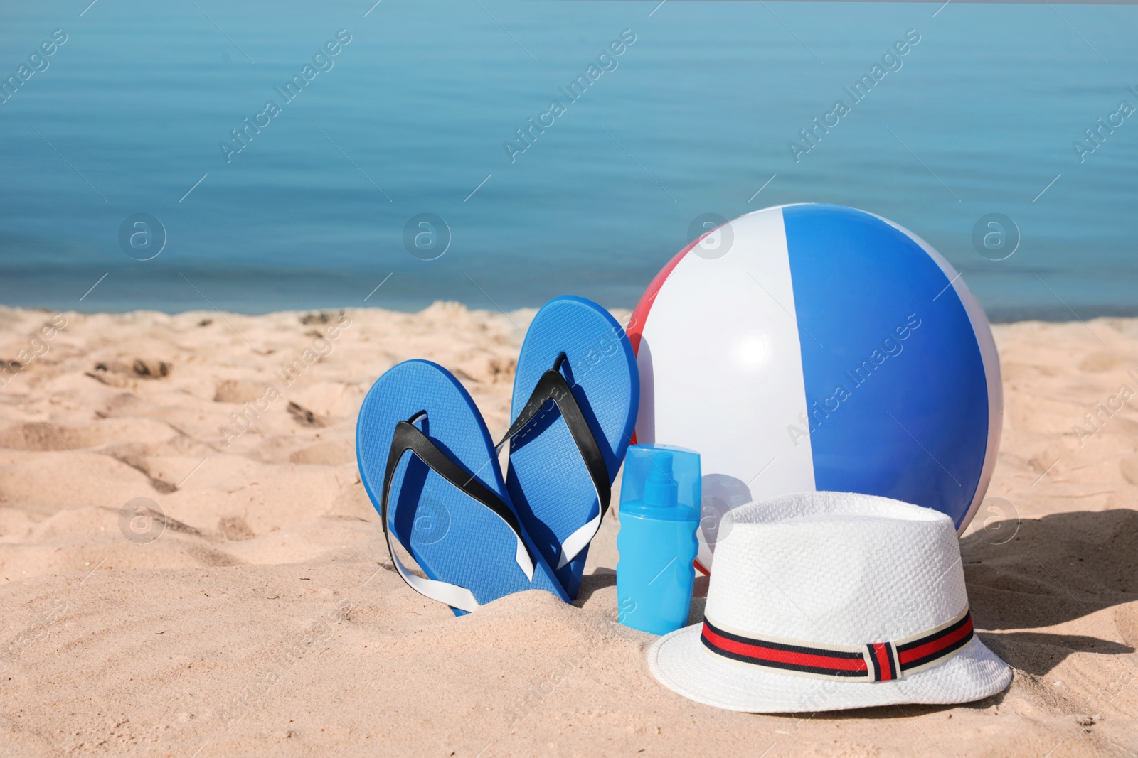 Photo of Beach accessories on sand near sea. Space for text