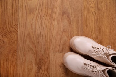 Photo of Pair of stylish beige leather shoes on wooden floor, top view. Space for text