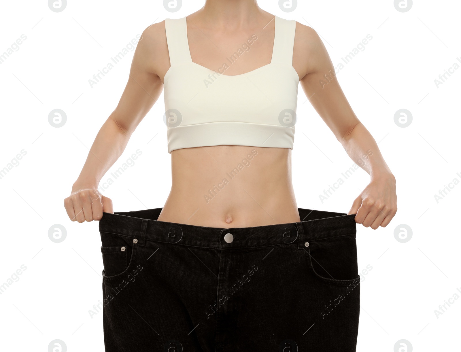 Photo of Young woman wearing big jeans after weight loss on white background, closeup