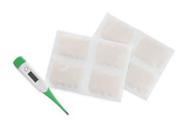 Photo of Mustard plasters and thermometer on white background, top view